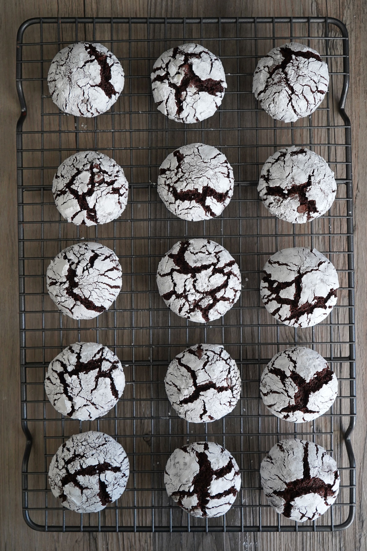 Chocolate crinkle cookies cooling on wire rack.