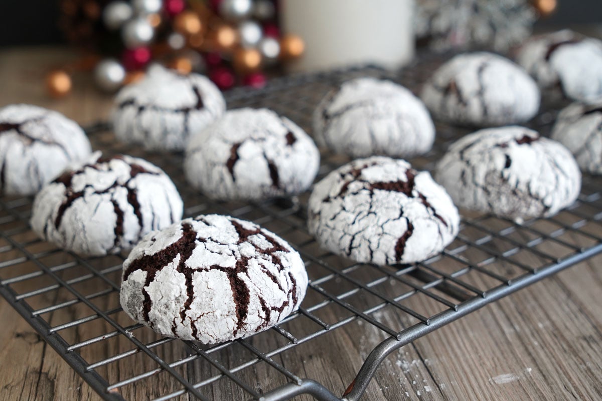 Chocolate crinkle cookies on wire rack.