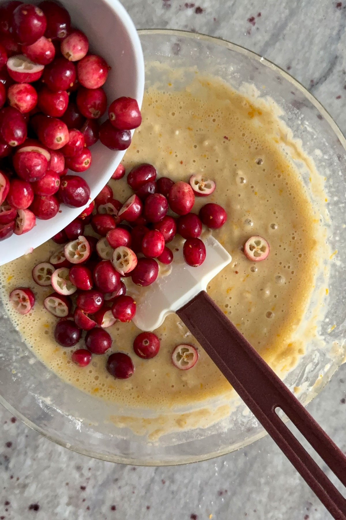 Cranberries being folded in to the orange cranberry bread batter.