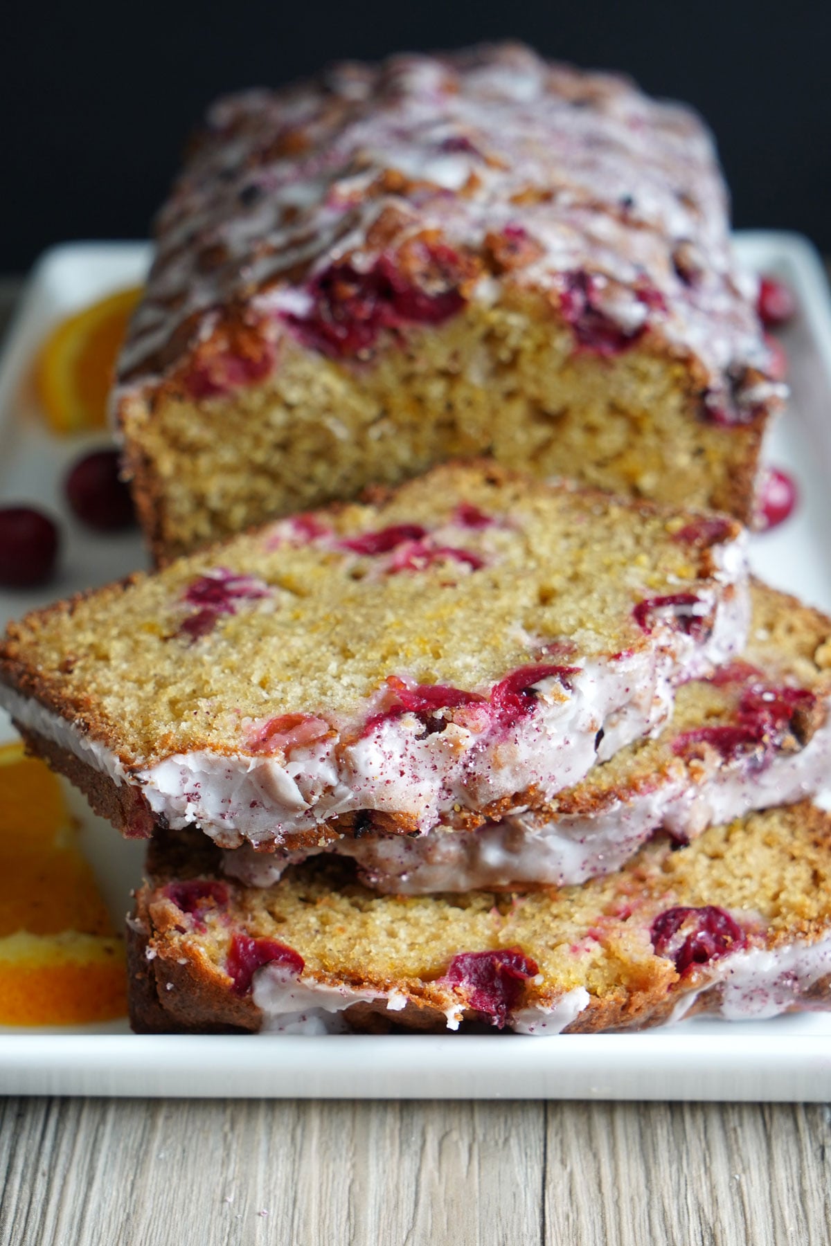Orange cranberry bread in sliced in a white platter.