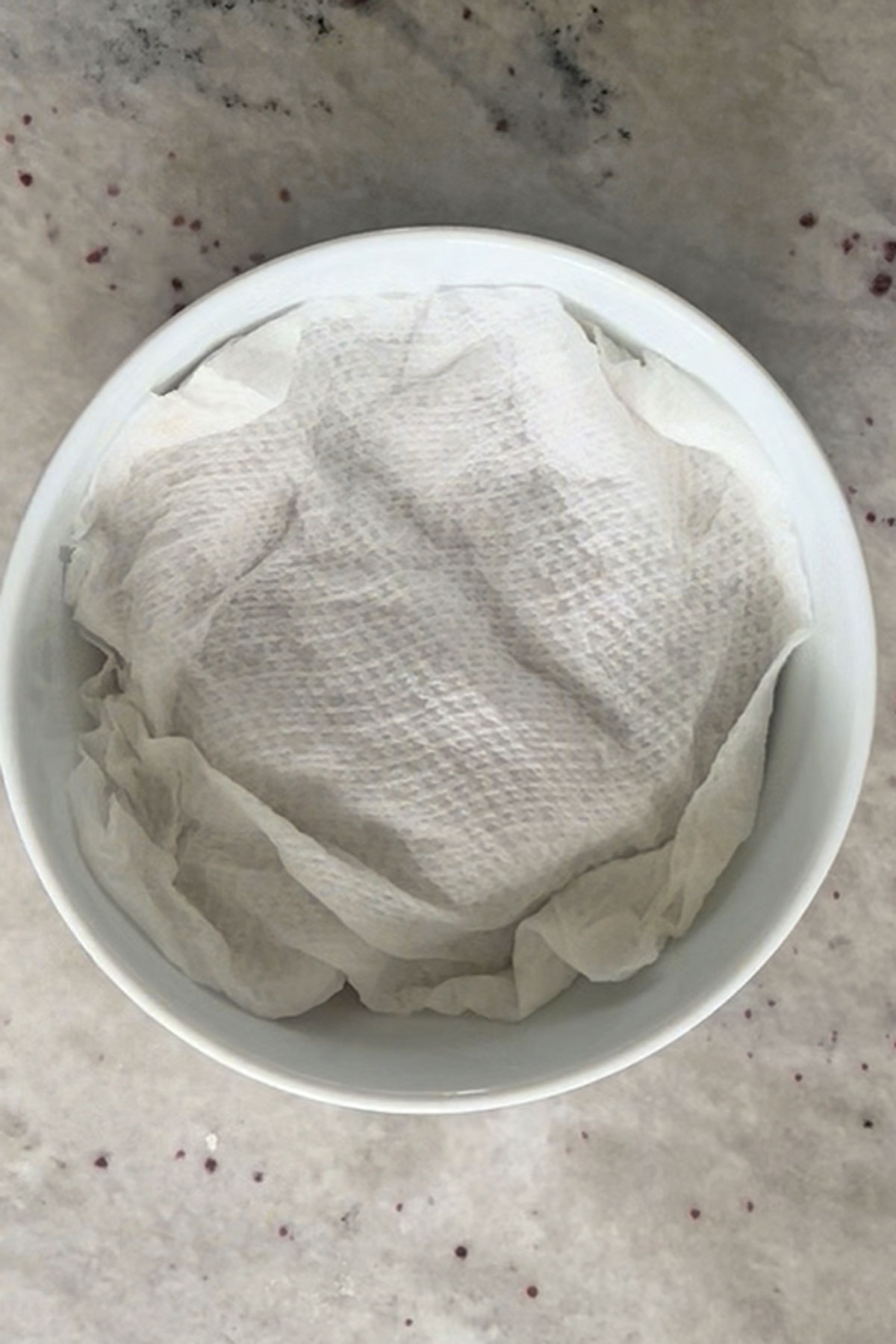 Wet paper towel placed of hardened brown sugar to prepare for softening using the microwave.