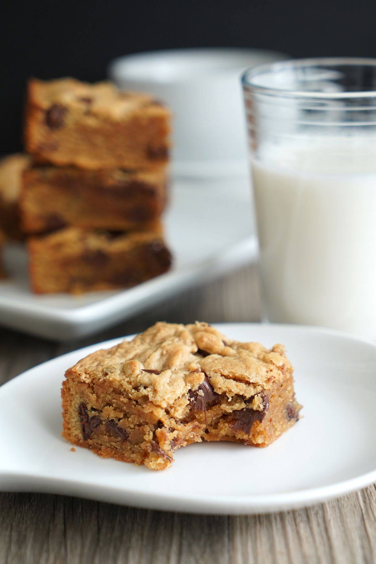 Peanut butter chocolate chip bar served with milk with bite taken out. 
