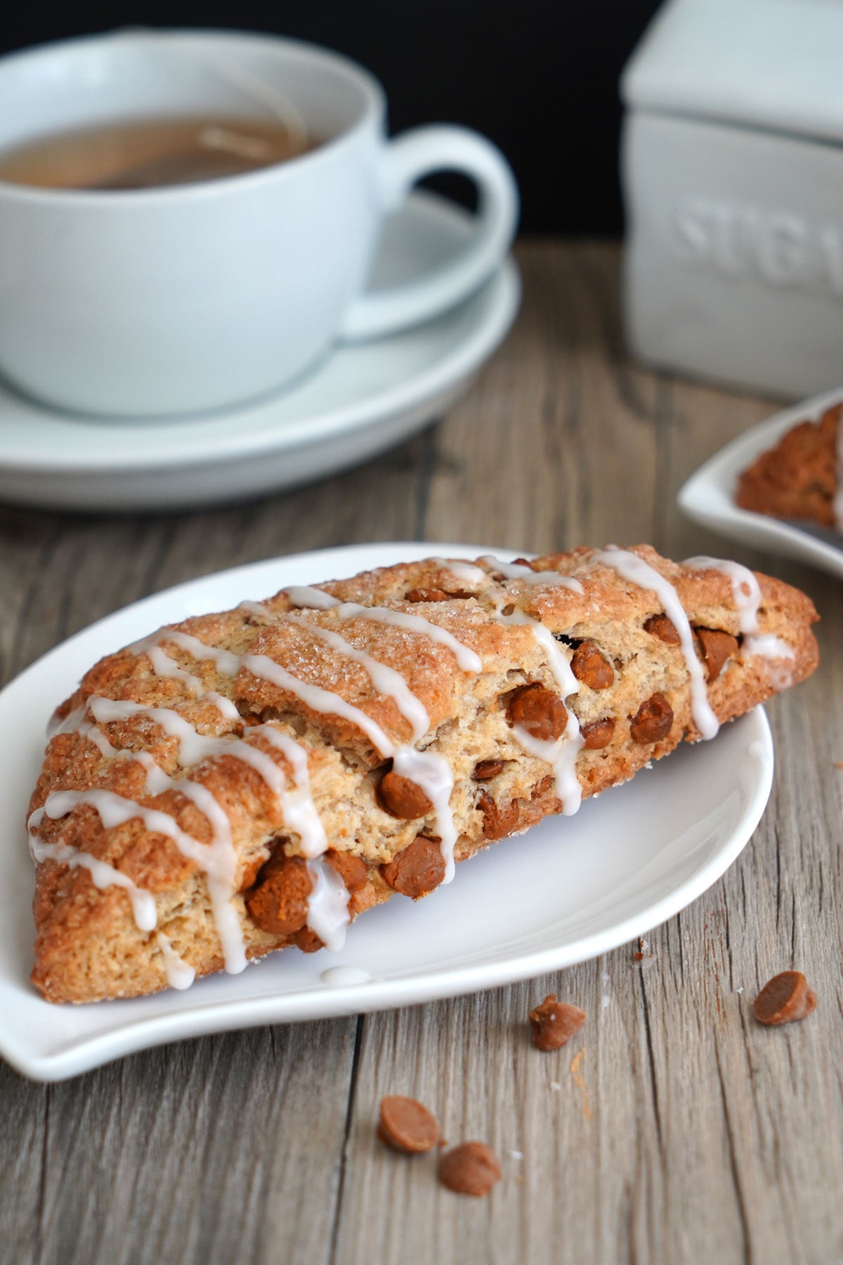 Close up of a cinnamon chip scone in a white plate.