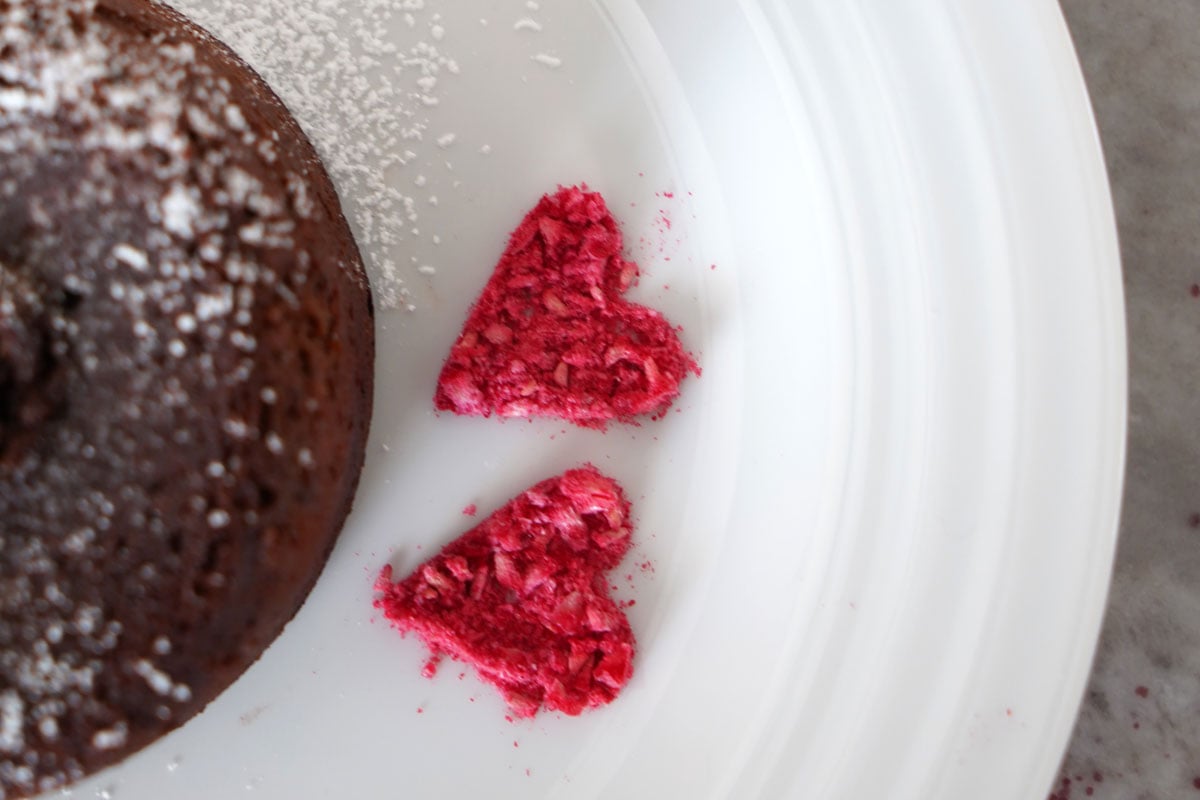 Close up of heart design on plate made with freeze dries raspberry crumbs.
