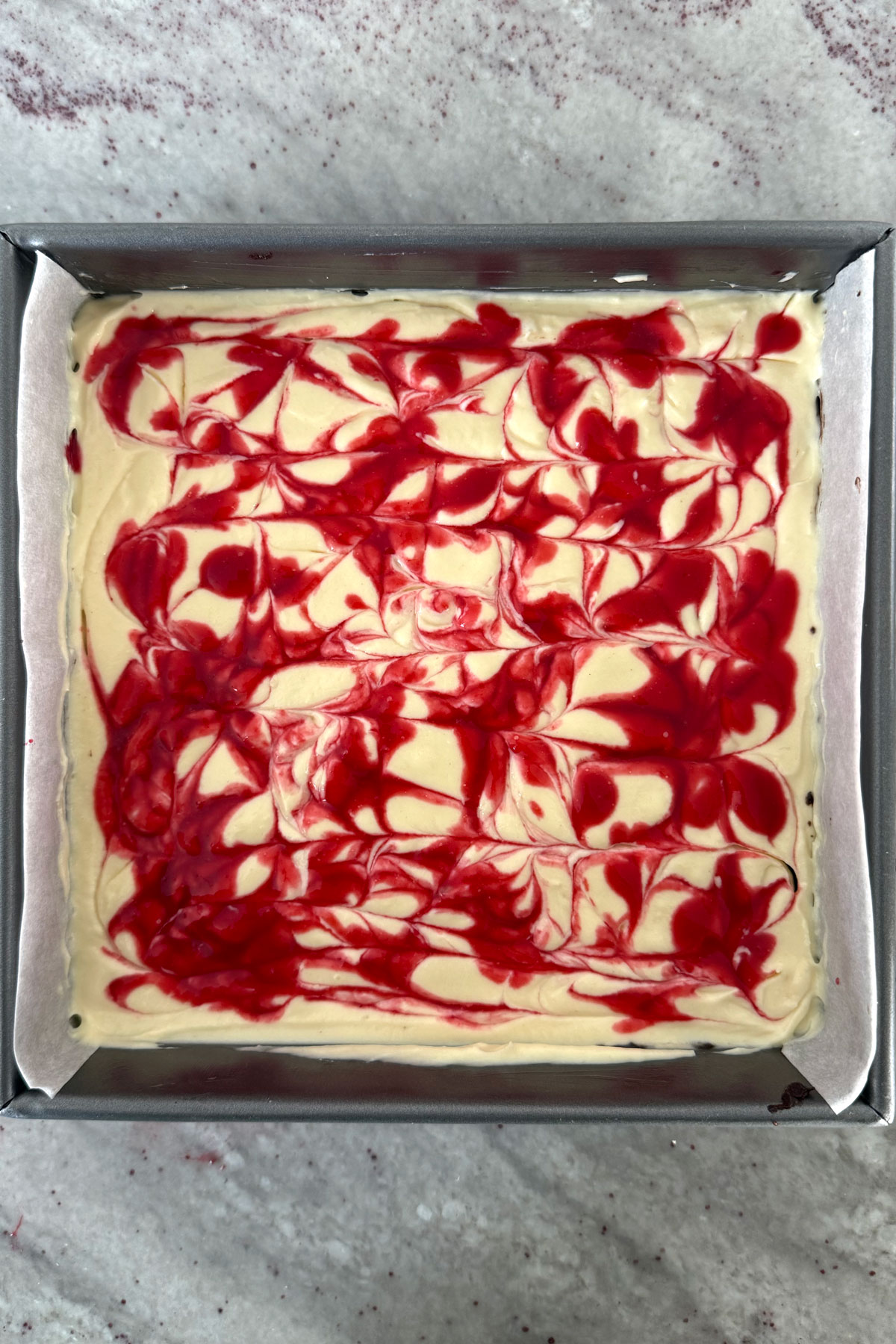 Raspberry sauce swirled into cheesecake batter.