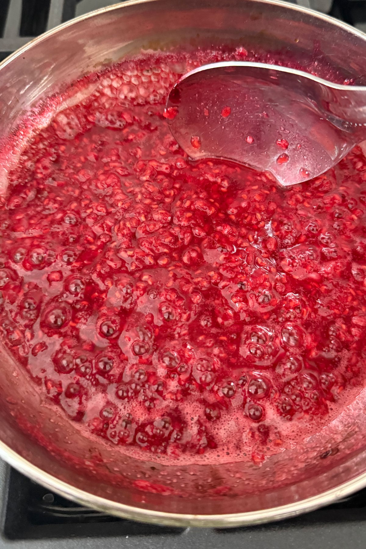 Raspberry sauce boiling on stove. 
