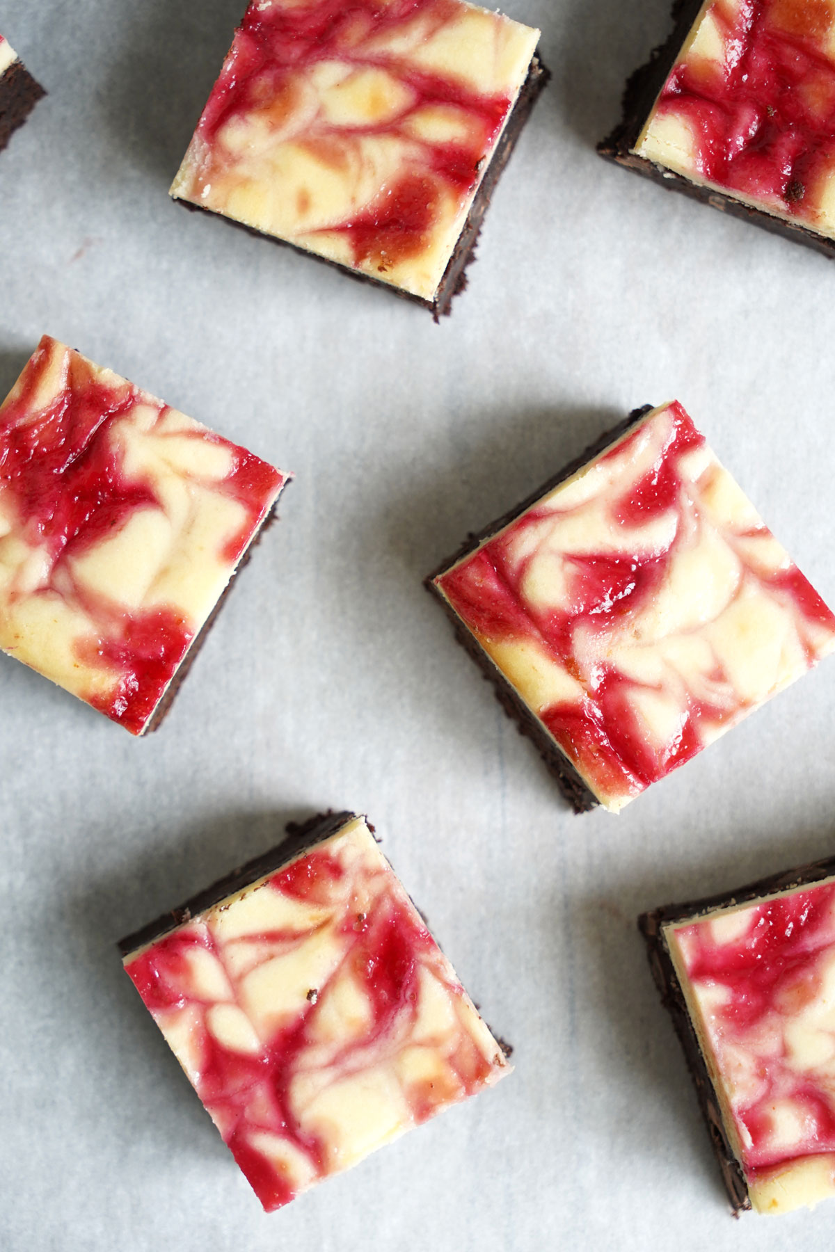 Cut raspberry cheesecake brownies on parchment paper. 