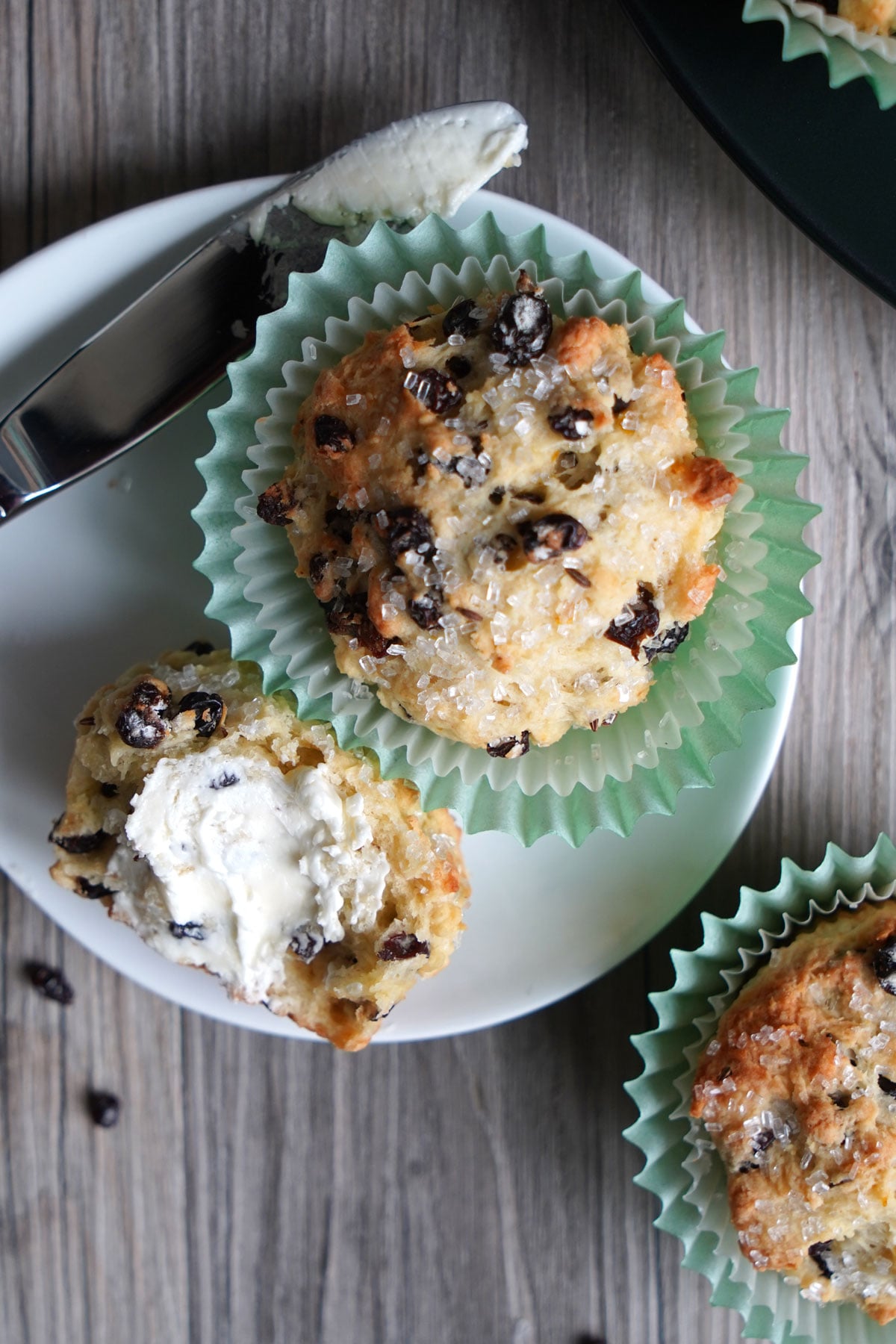 Butter spread on muffin half in plate. 