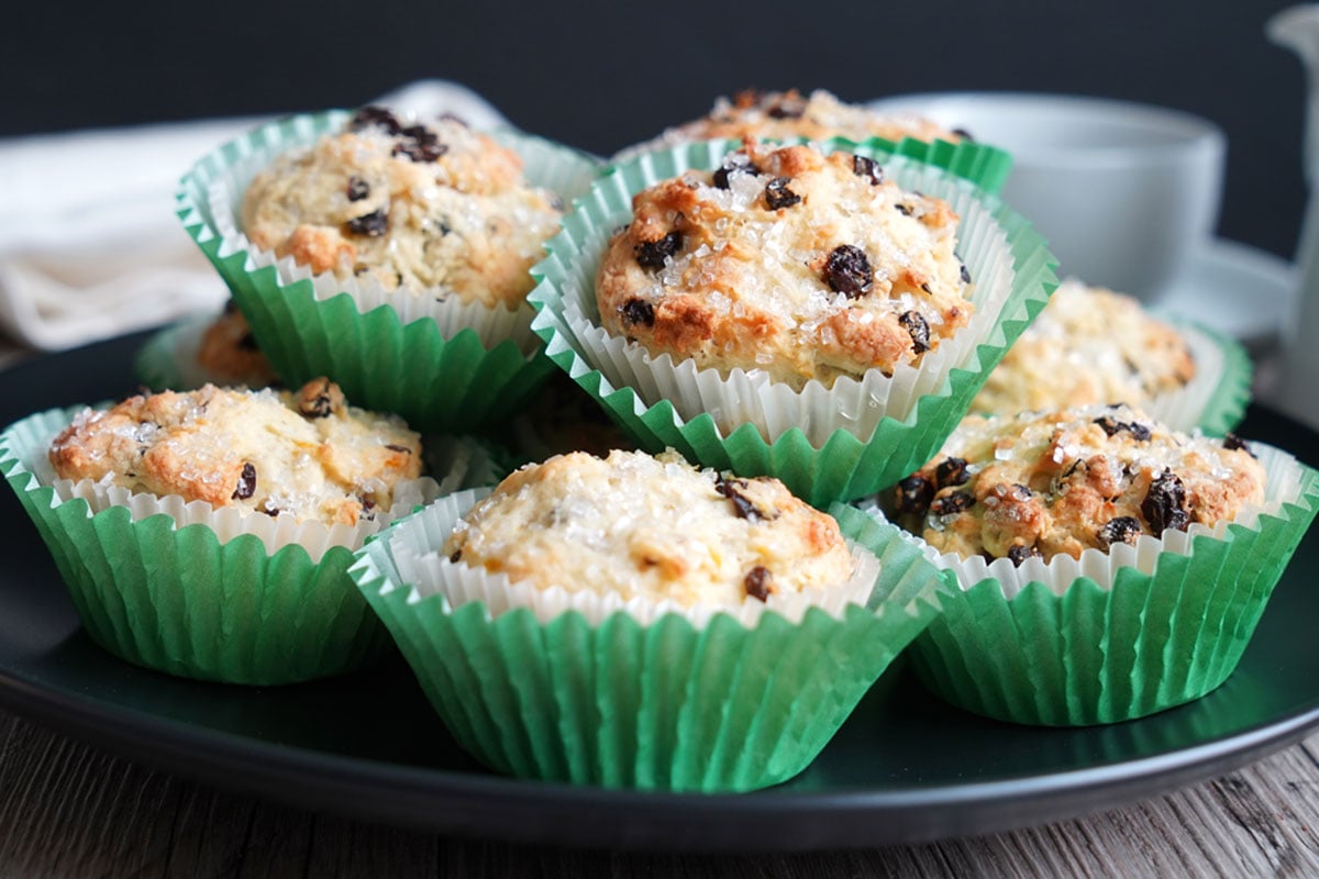 Irish soda bread muffins stacked on a black plate.