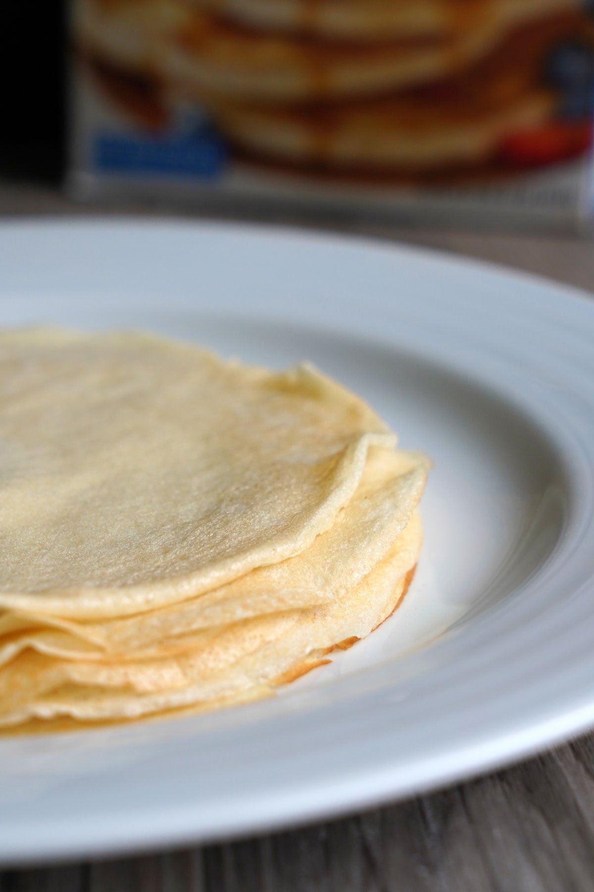 Stack of cooked crepes on a plate. 