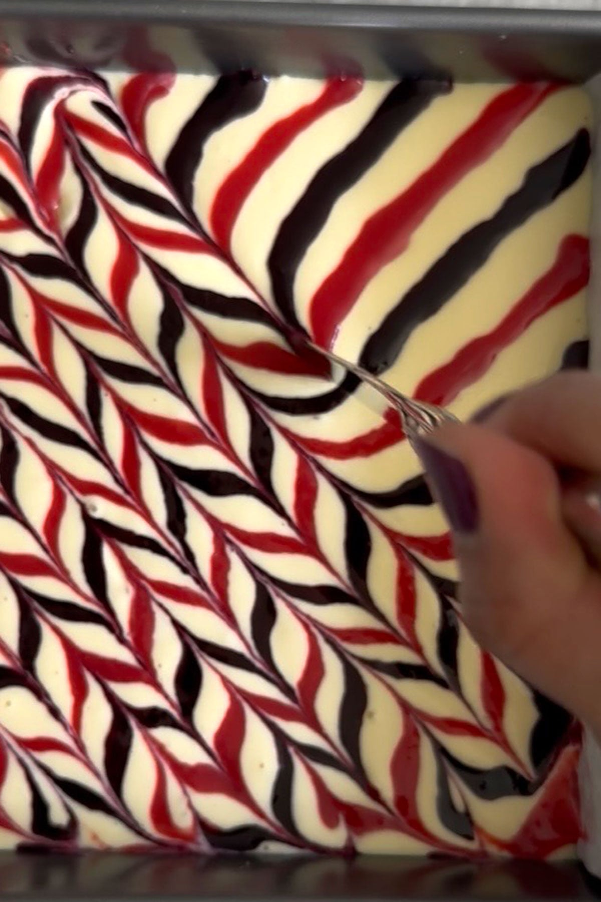Berry sauces being swirled into batter.