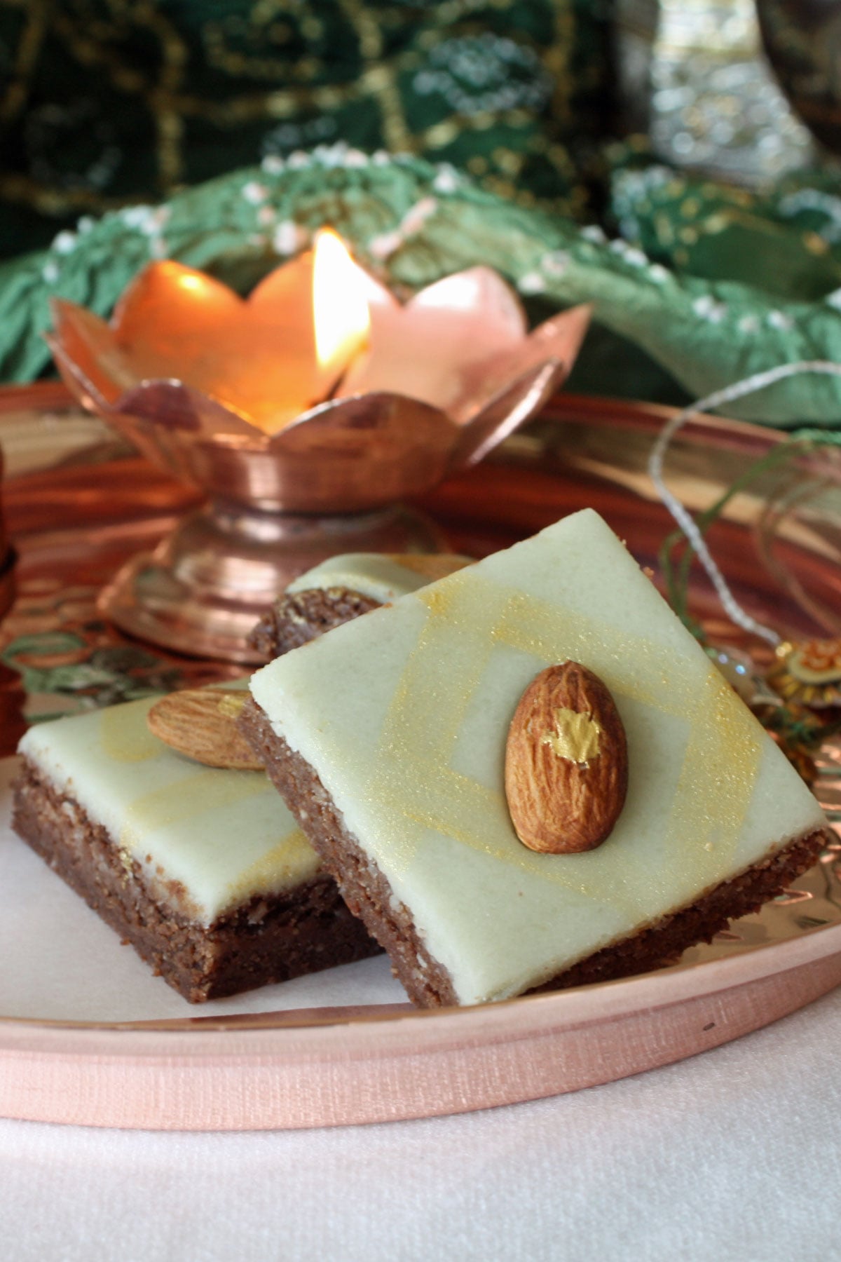Chocolate brafi in a copper thali with diya and rakhis for Raksha Bandhan.