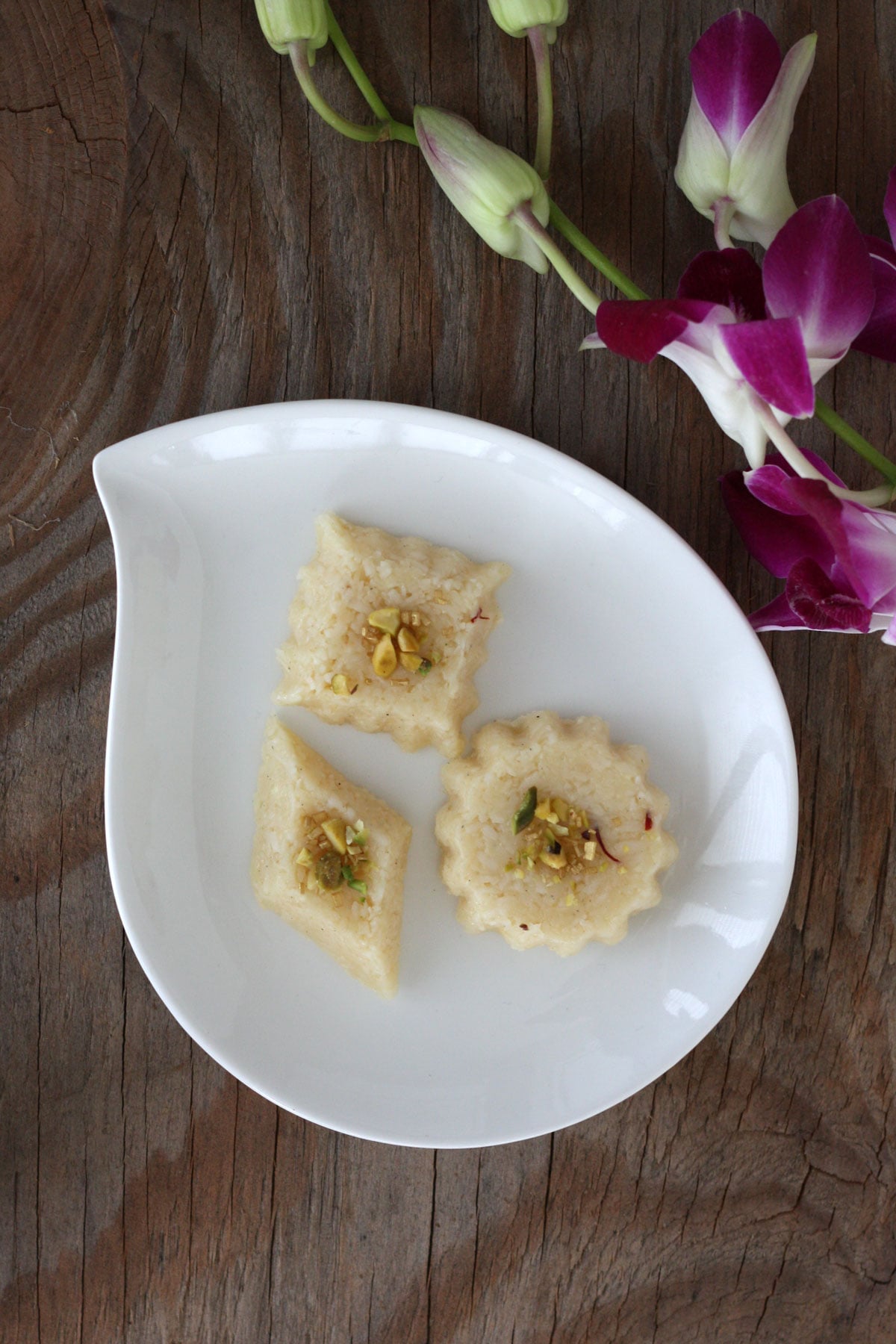 Coconut barfi with condensed milk in a white dish.
