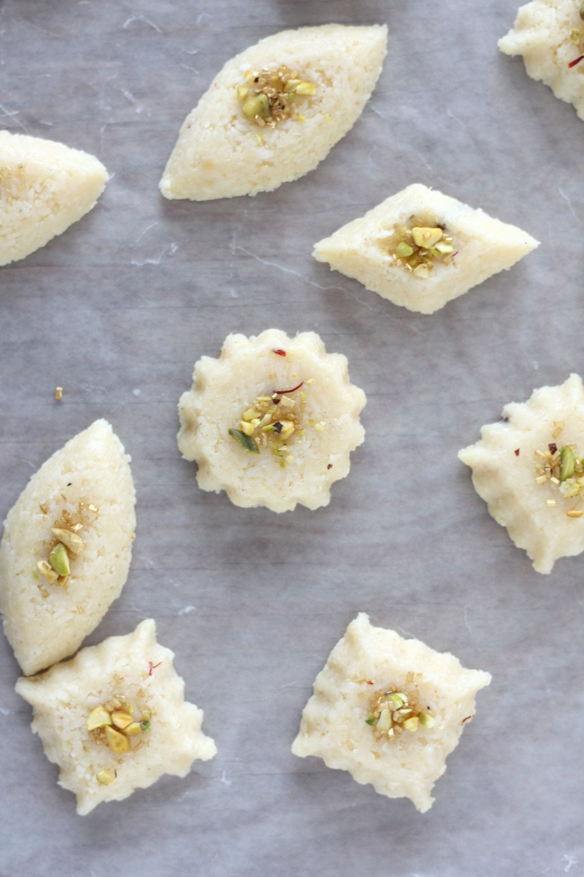 Coconut burfi shaped by pressing into petit four molds.