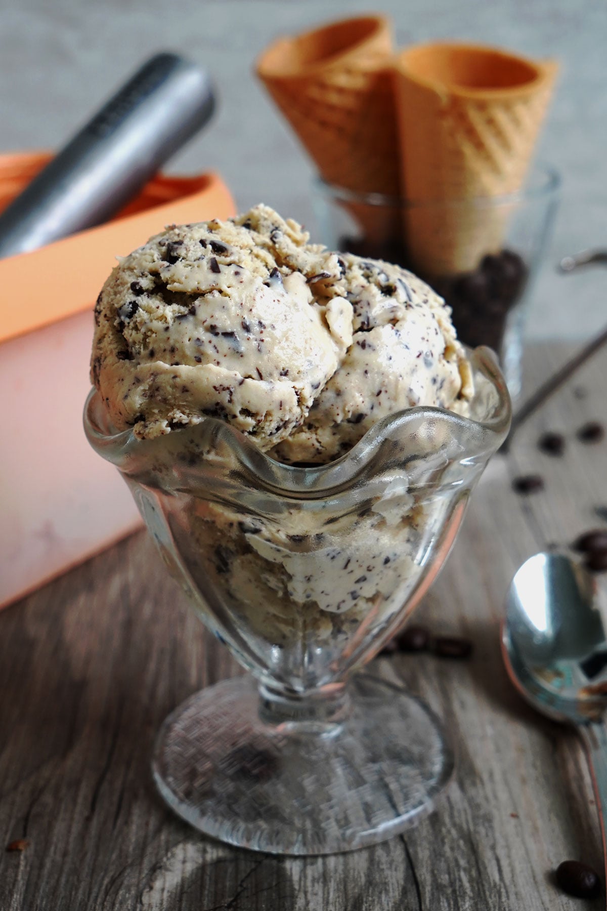 Espresso ice cream with chocolate chips scooped into a dessert glass.
