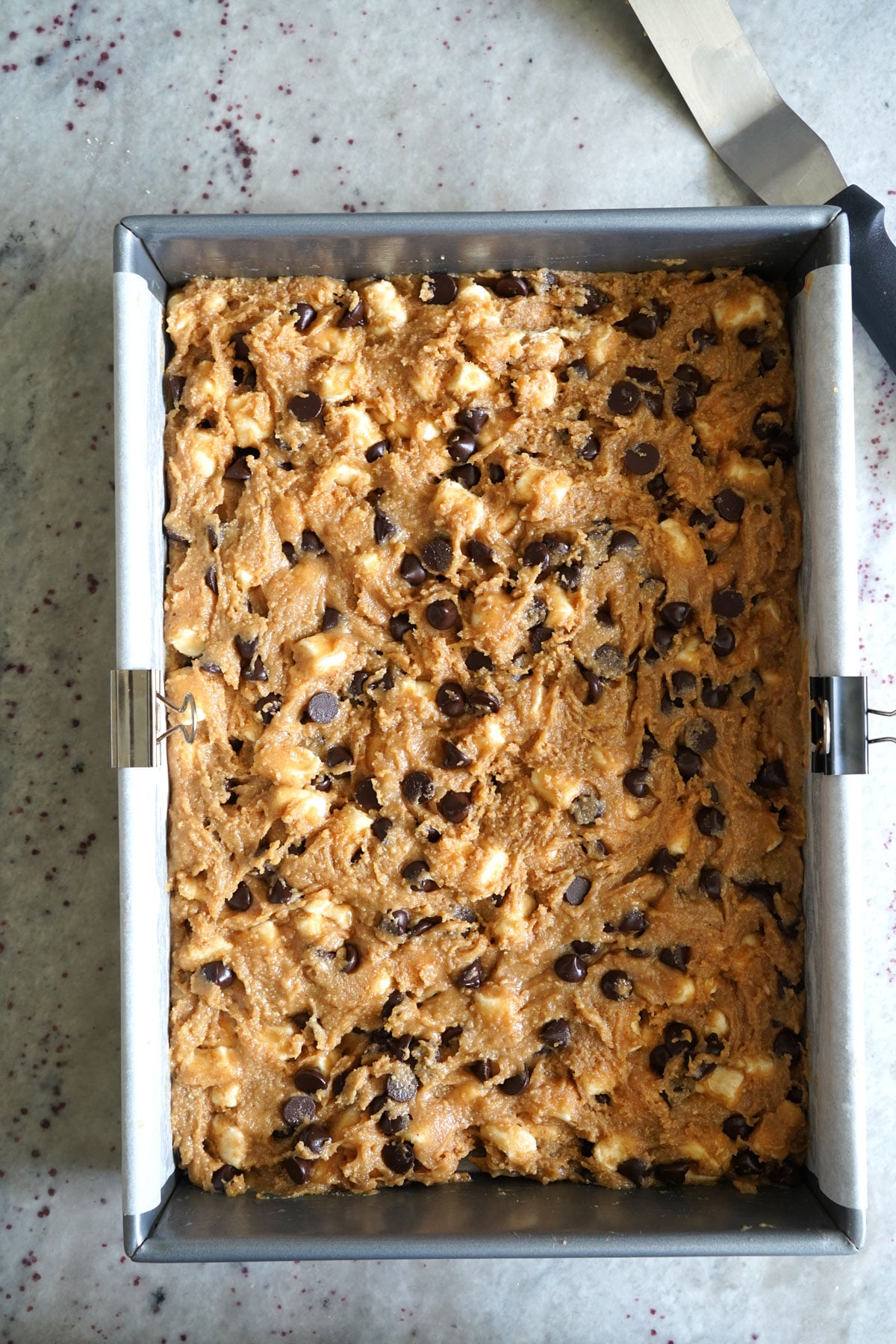Chocolate chip marshmallow cookie bar dough spread into 9x13 pan.