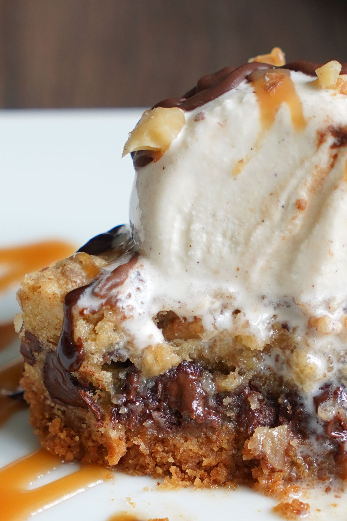 A close up view of the layers of the paradise pie cookie bar with ice cream melting into it.