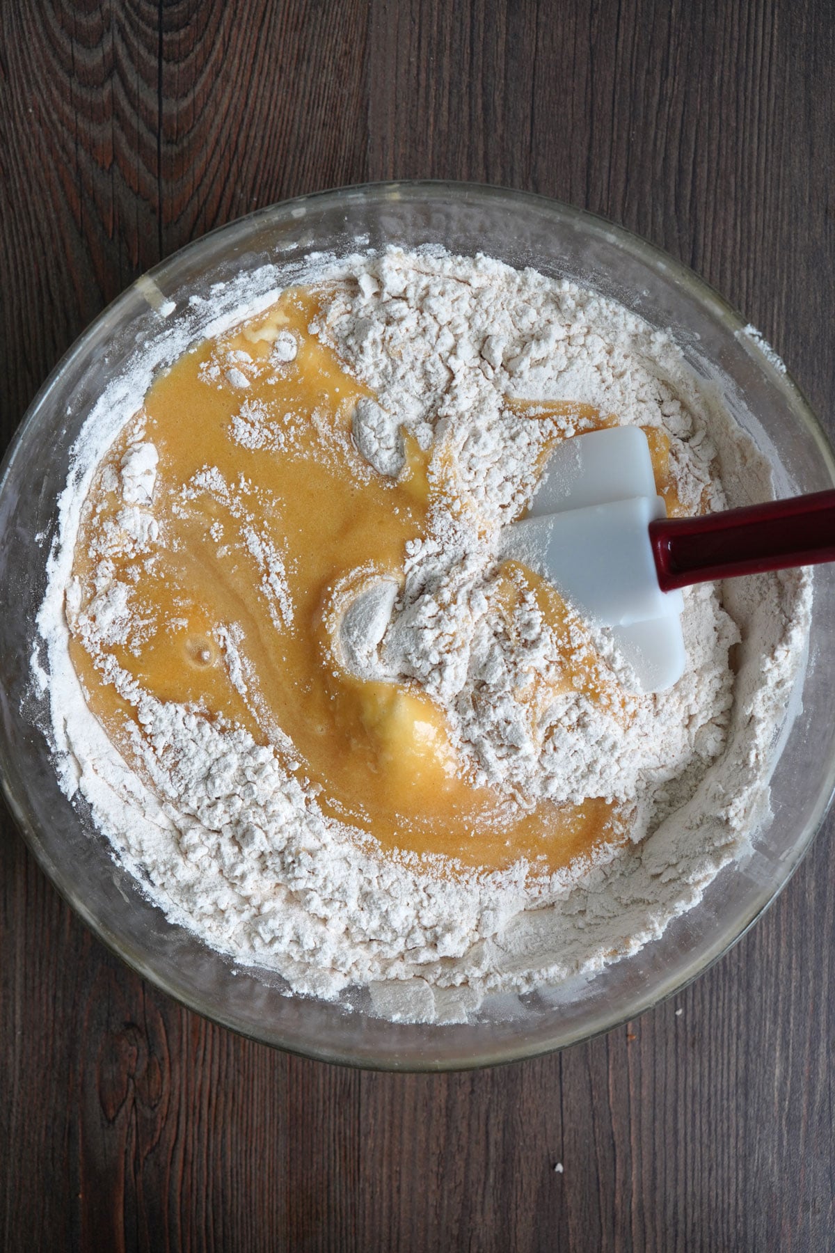 Cookie bar batter being mixed in a bowl showing dry ingredients mixed into wet ingredients.