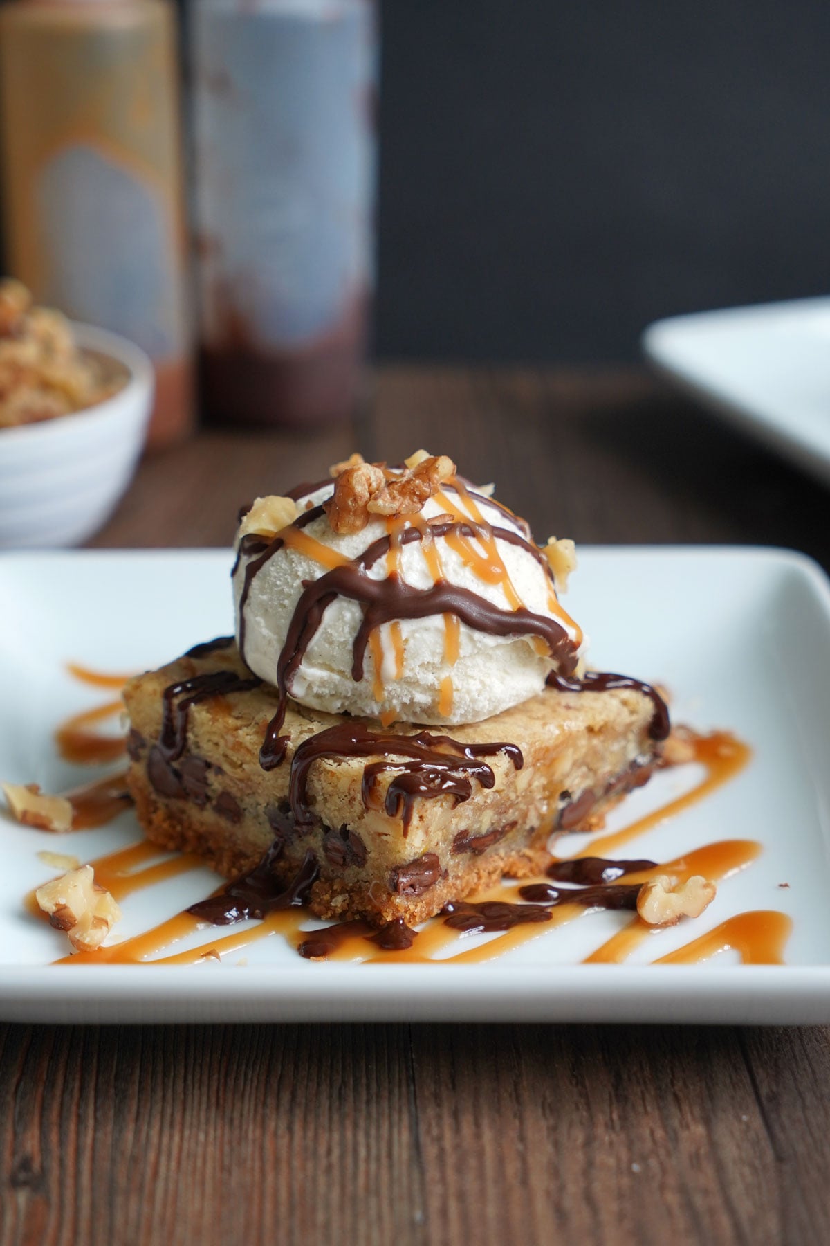 A warm paradise pie bar topped with vanilla ice cream and drizzled with chocolate sauce and caramel sauce.