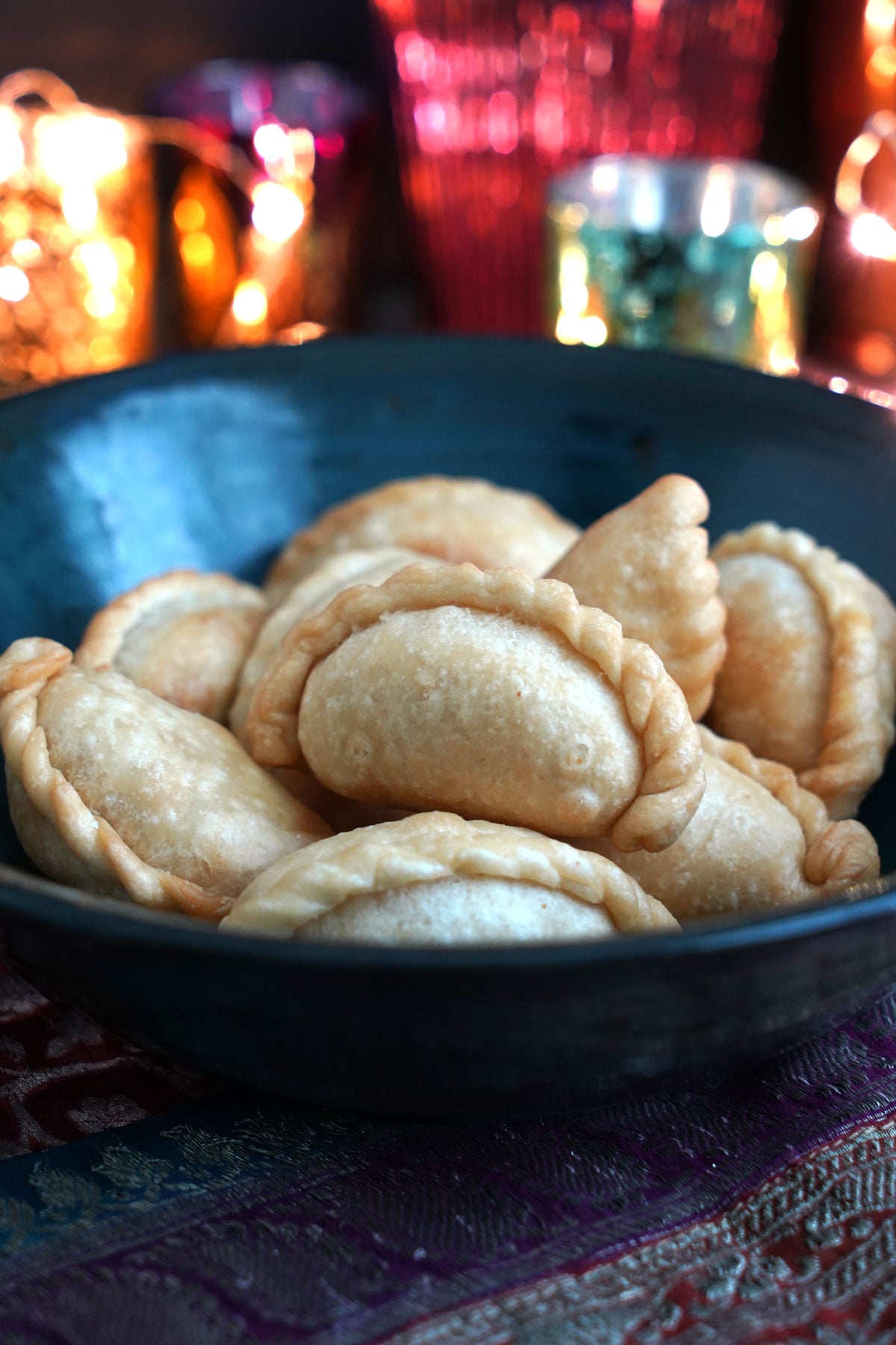 Ghughra in a bowl with Diwali candles in the back.
