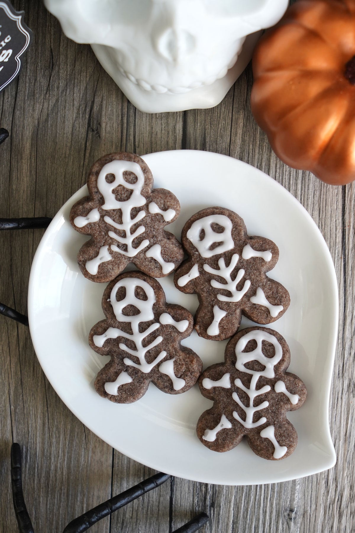 Small skeleton cookies piped with white icing lines on speckled Oreo dough.